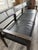 Ben Soleimani “Benton” bench in black leather and dark cerused oak, featuring a beautifully architectural silhouette with...