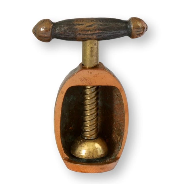 A rare German GES. GESCHTZT nutcracker in the shape of a walnut, crafted from solid copper and brass with a darkened...