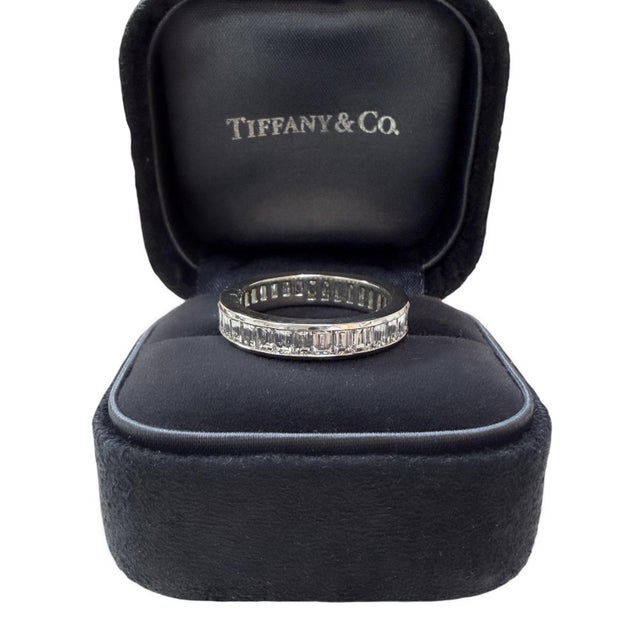This beautifully classic ring by Tiffany & Co. contains 33 channel set baguette cut diamonds weighing approximately 3.60...