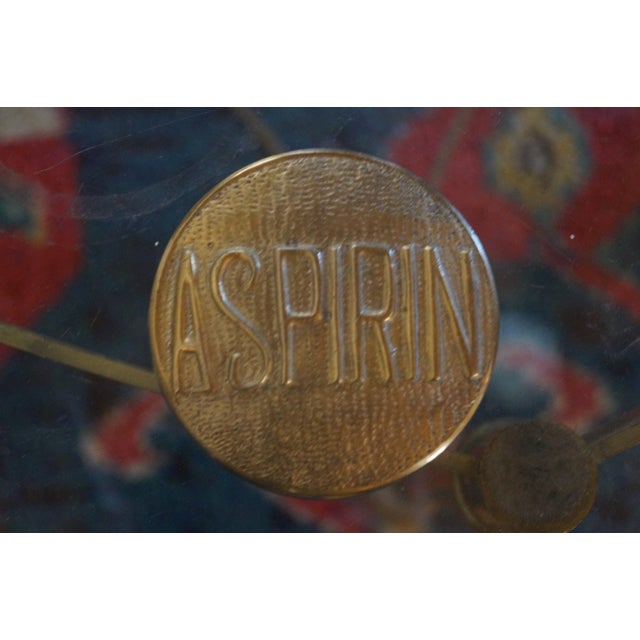 A classic vintage brass paperweight which is in the shape of a big aspirin. Very cool and unpolished. Measures .75 inches...