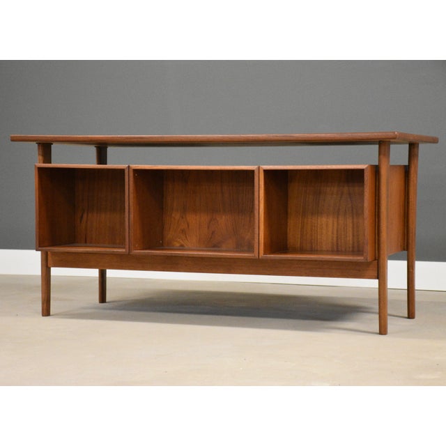 A mid century modern teak floating top desk designed by Kai Kristiansen with a drawer with the capability for hanging...