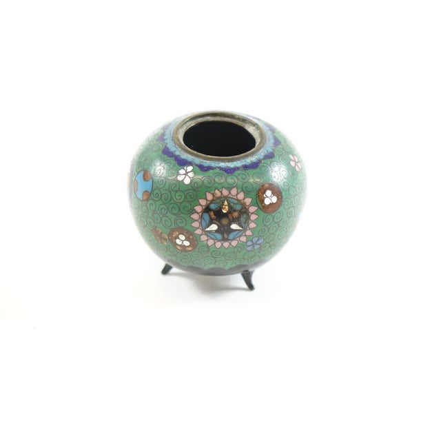 This early 20th-century Chinese cloisonné vase features a vibrant green background, adorned with bold geometric shapes and...