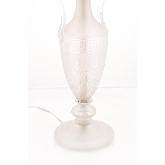 A refined frosted glass 'Grecian Urn" etched table lamp accented with graceful scrolling handles. Elegant proportions and...