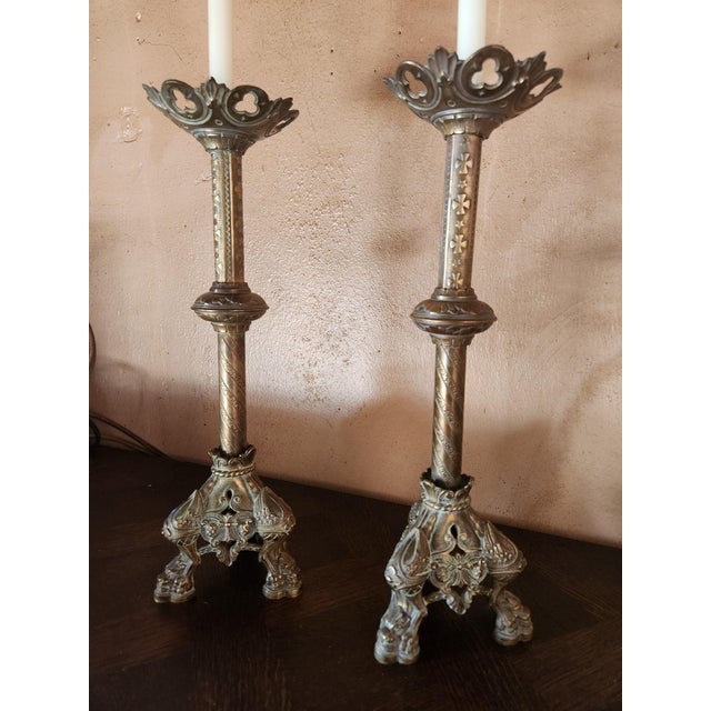 A fine, heavy pair of 19th Century French brass church candlesticks, elaborately embossed. Stunning details on the feet...