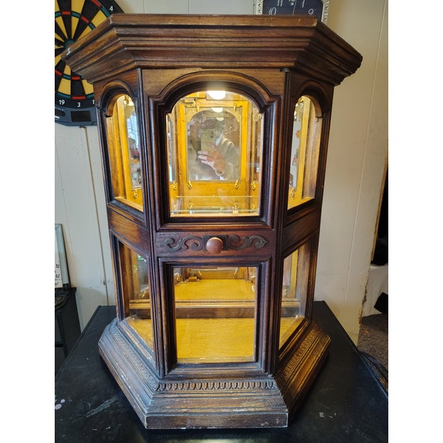 This antique oak display cabinet, possibly dating from the late 19th to early 20th century, showcases the craftsmanship of...