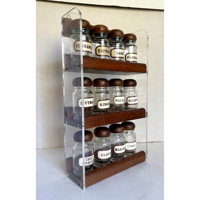 Here is a wonderful, mid-century modern spice rack featuring 12 glass bottles with wood tops, beautifully displayed in a...