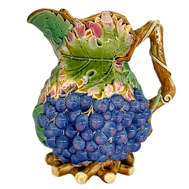 T. C. Brown-Westhead, Moore & Co. Majolica Wine Jug is molded as bunches of purple-glazed grapes with grape leaves and...
