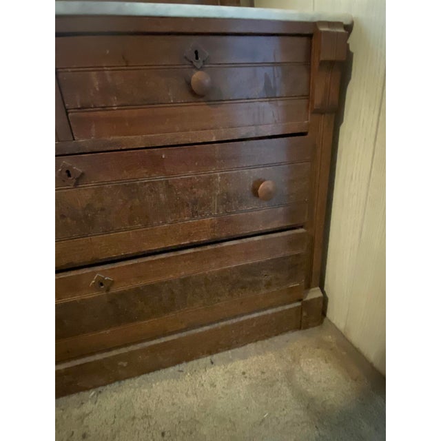 Victorian Eastlake style dresser with marble top and attached mirror. This Eastlake style popular in the latter half of...