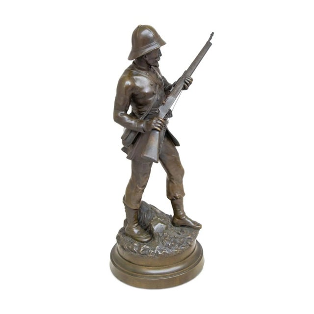 French Soldier Patinated Bronze Sculpture, late 19th century, the figure depicted in tropical uniform, carrying a rifle at...