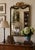 An elegant Italian giltwood mirror featuring carved floral swags, ribbon cresting, and a beautifully muted blue painted...