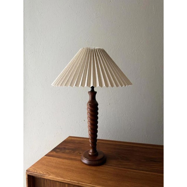 Sculptural wooden table lamp with pleated lampshade. A lamp that instantly brings tranquility to the room. The turned...
