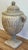 Oversized resin urn featuring rams head "handles" to either side with large finial to detailed lid atop intricately carved...