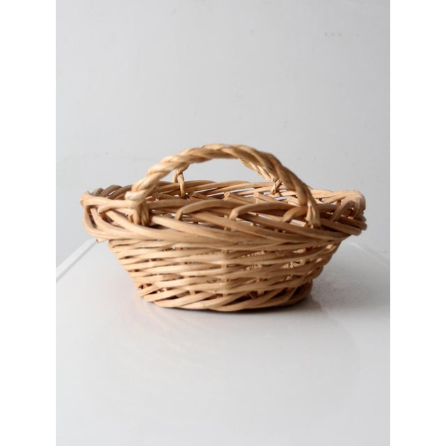 This large vintage oval gathering basket features an open handwoven pattern and gracefully arched handles that highlight...