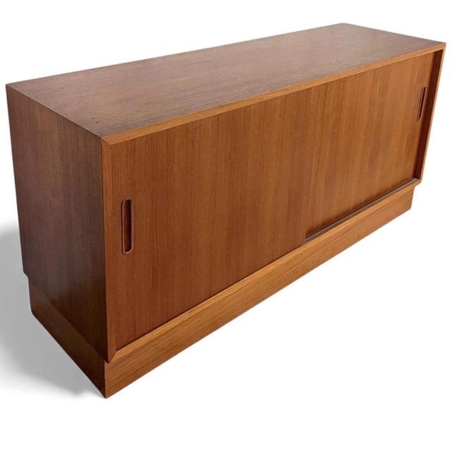 The Danish teak sideboard is a mid-century low cabinet designed to provide stylish sliding door storage while enhancing...