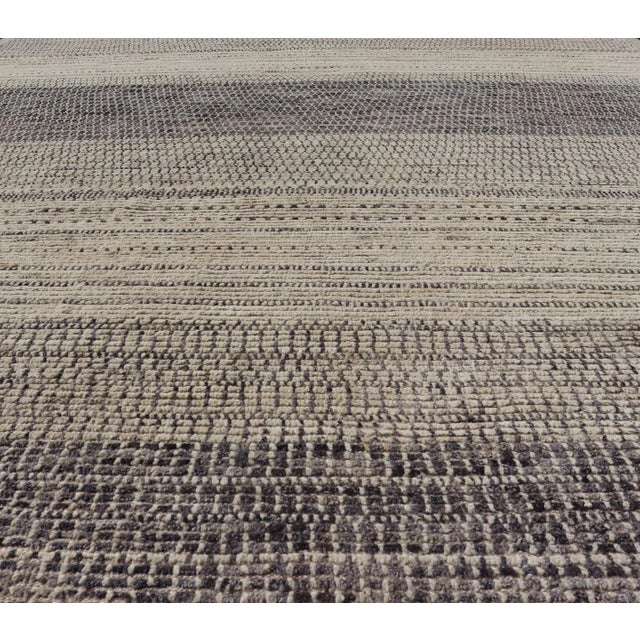 This modern casual tribal rug has been hand-knotted in wool. The rug features an all-over modern sub-geometric horizontal...