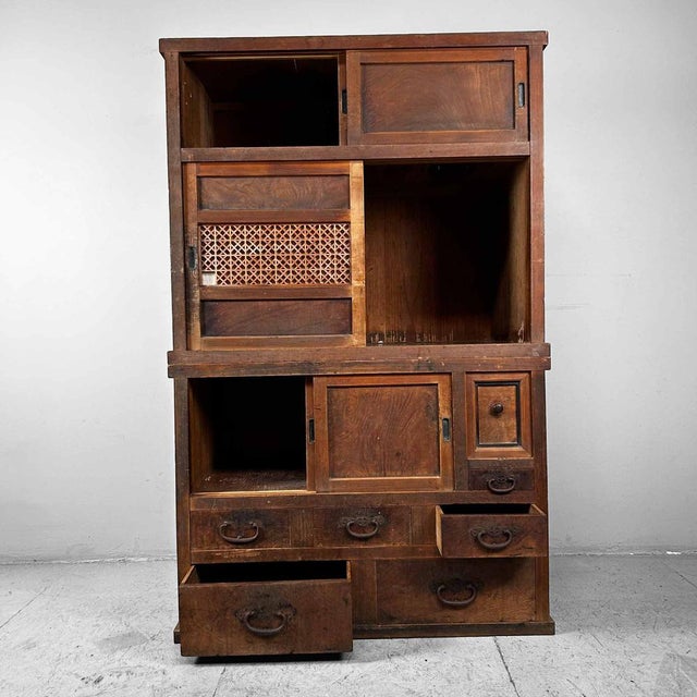 Beautiful two-piece wooden Japanese cabinet (tansu) from the Taishō period. This decorative furniture features three...