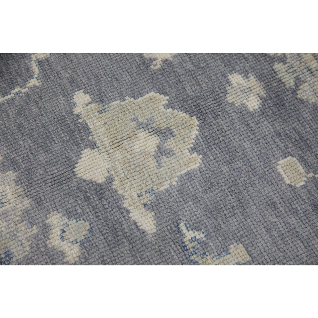 This modern Turkish Oushak rug is a stunning piece of art that has been handwoven using traditional techniques by skilled...