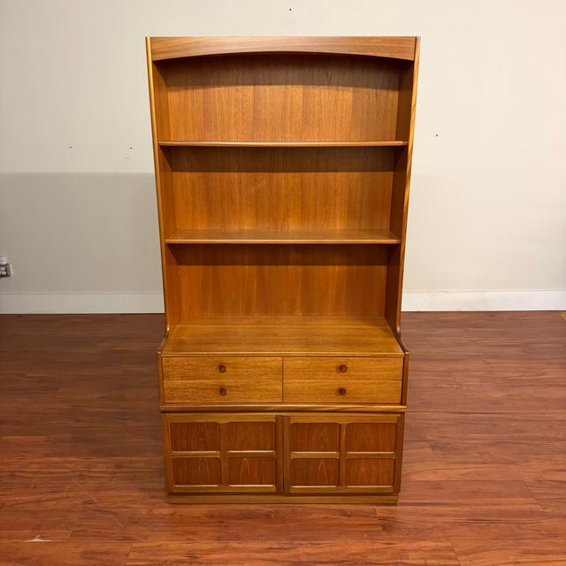 Vintage teak bookcase cabinet made in the U.K. by Nathan Furniture circa 1970's. It offers two upper shelves, the top one...