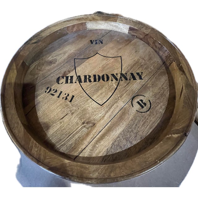 Round decorative wine-barrel style serving tray crafted from wood staves with a raised rim and metal banding, designed to...