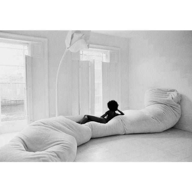 Interior Design, 1970s A naked woman lounging on an extra long beanbag sofa in a all-white furnished room, UK, 12th March...