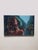 Dreaming of the City 2 presents a striking interplay between a contemplative figure and a vibrant urban backdrop. The oil...