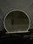 A large round mirror with a soft cream-colored frame and a clean sculptural base. The rounded silhouette and neutral...