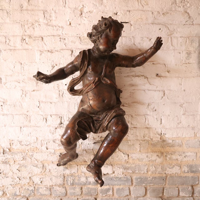Add dramatic Baroque artistry to your space with this 17th century Italian carved walnut cherub statue, a striking example...