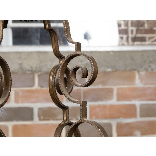 A French Art Deco period wrought iron eight-light chandelier from circa 1920 with large scrolling motifs. This exquisite...