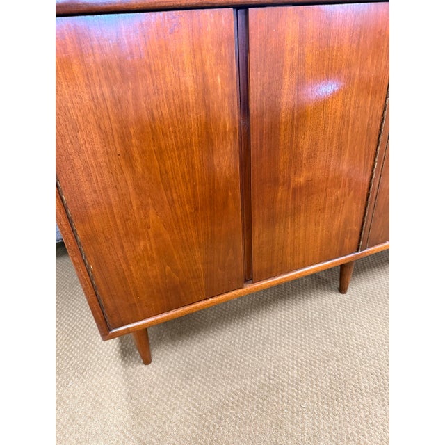 Mid-century Foster McDavid credenza featuring a clean-lined four-door case on tapered legs, spacious interior storage,...
