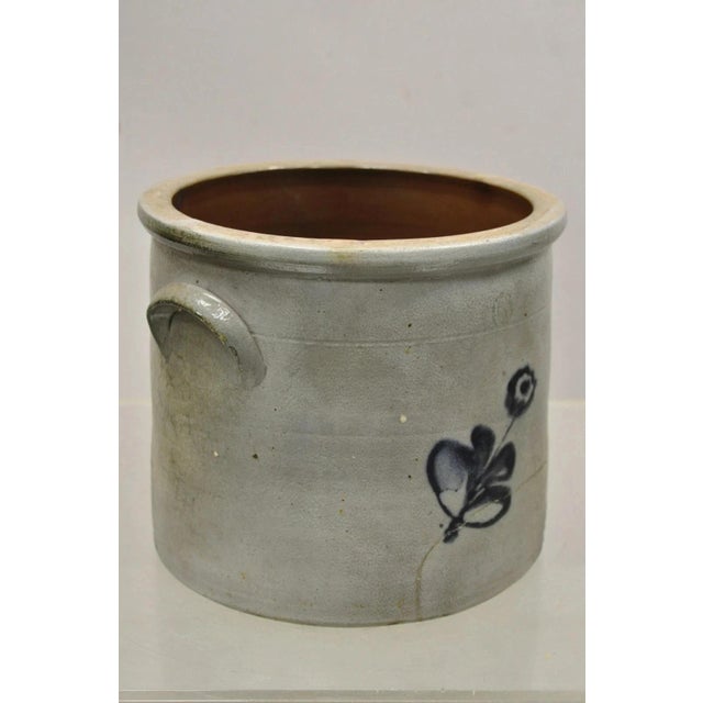 Antique Stoneware Salt Glazed 9" Round Pottery Crock Pot with Blue Flower. Circa Late 19th Century. Measurements: 8" H x...