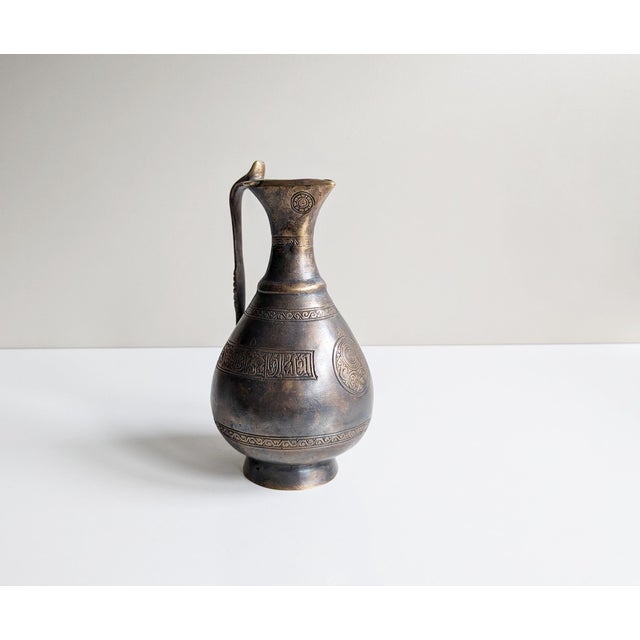 This bronze jug was made based on a historical model in the 1970s. A heavy bronze, dark patinated with ornamental relief...