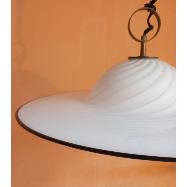 Elegant pendant lamp with a vintage design, crafted from hand-blown Murano glass in a milky white color with a black...