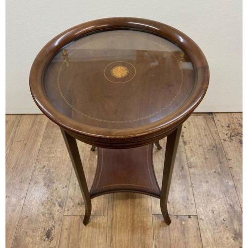 A Sheraton Revival side table in mahogany. Circa 1920. The table has a circular mahogany top with a crossbanded and inlaid...