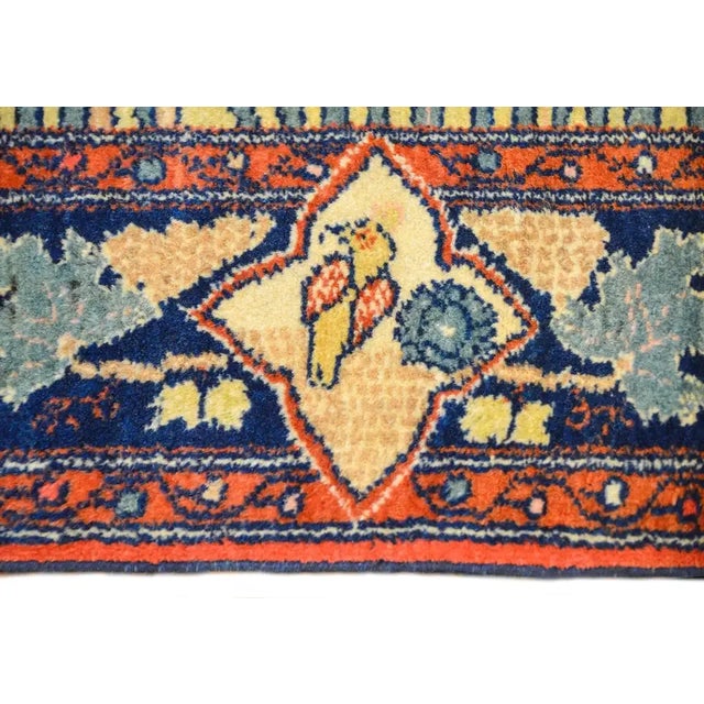 A whimsical early 20th century Persian Bakhtiari rug with a sweet landscape depicting birds perched in a flowering trees....