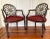 A lovely pair of vintage, spider-back arm chairs in a classic Hollywood Regency silhouette, with dark stained wood, carved...