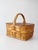Vintage wicker picnic basket featuring a warm woven finish, divided wood veneer lids, and a wrapped handle. The honey-...