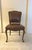 Elegant side chair featuring rich brown upholstered seat and back accented with decorative nailhead trim. The chair...
