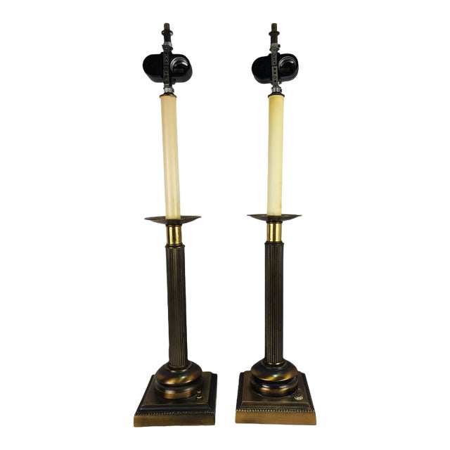 A distinguished pair of Regency‑style brass candlestick lamps, attributed to Robert Abbey, offering timeless elegance for...