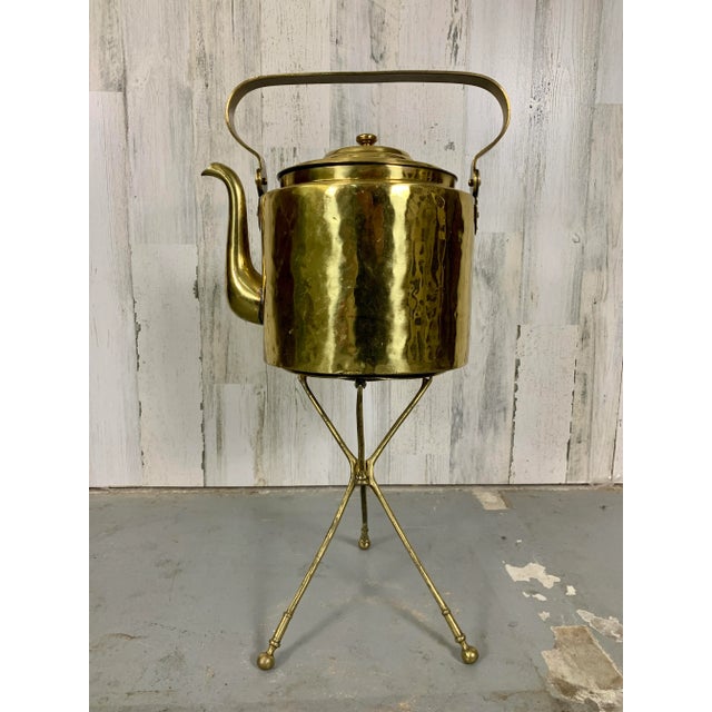 Folding tripod trivet with large coffee pot used for fireside heating of hot water in Holland early 20th century.