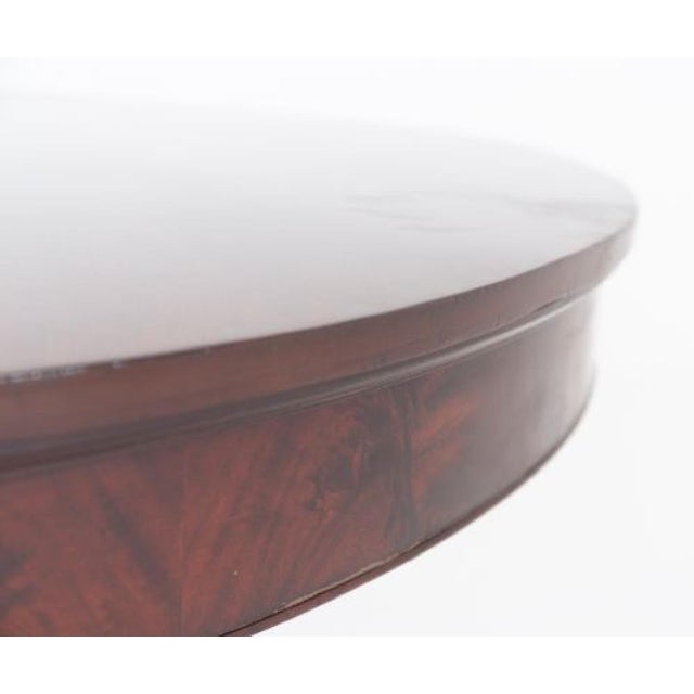 An impressive and substantial split-base dining table of circular form when closed, offering both elegance and versatility...