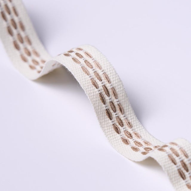 Stitches in variegated tones form a dappled stripe pattern on an understated high-performance tape with loads of tactile...