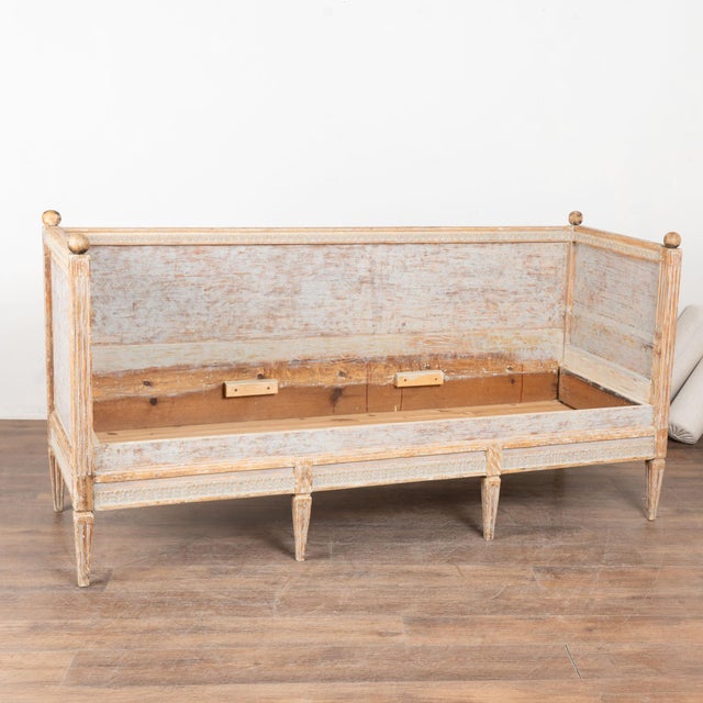 Early 19th century Swedish Gustavian bench or settee crafted in pine. The bench retains an original blue-gray painted...