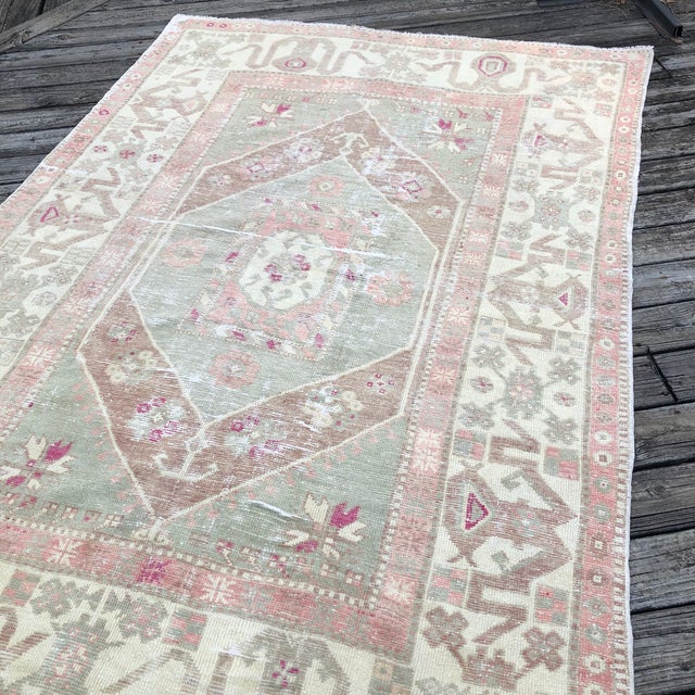 A Distressed Antique Turkish Rug with Soft Geometry and Floral Balance This antique Turkish rug is hand-knotted in the...