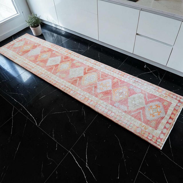 This authentic 1980s hand-knotted runner from Southeastern Anatolia features a beautifully faded geometric design,...
