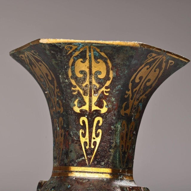 A matched pair of slender archaistic Chinese bronze beaker vases (*gu* 觚), the ritual wine vessel form of the Shang and...