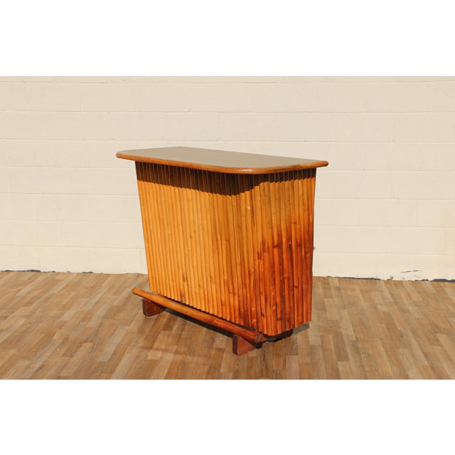 Stunning vintage bamboo tiki bar from the mid 20th century featuring an exceptional tropical design with warm natural...