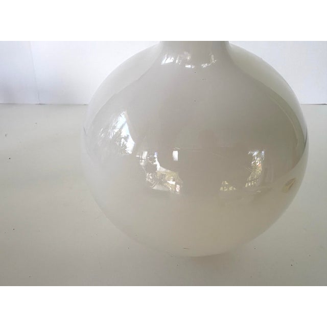 This elegant mid-century milk glass bath oil bottle features a classic bulbous body with a tall, slender neck and a...