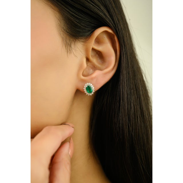 These stunning stud earrings feature 2 oval cut natural zambian emeralds totaling 1.41 carats, crafted in 14K white gold....