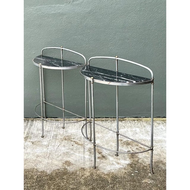 This set of two vintage demi-lune tables pairs black marble tops with slender metal frames, bringing a refined,...