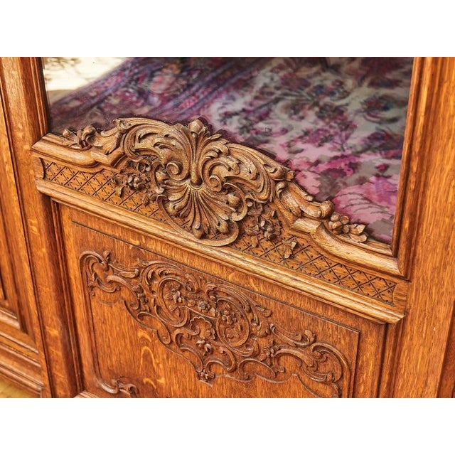 Richly carved bookcase made of solid oak with partially glazed doors and transoms decorated with carvings. The interior of...